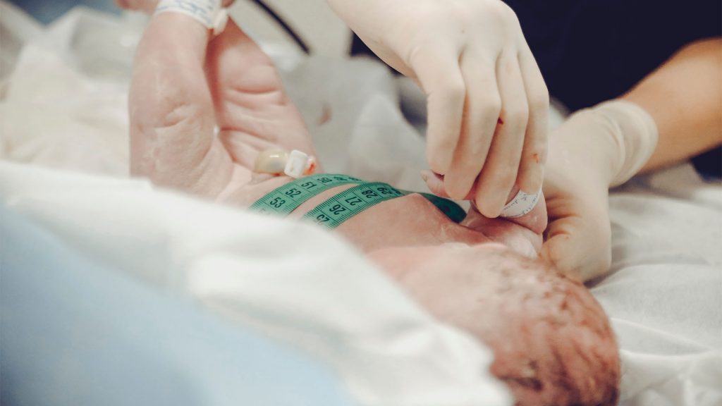 Baby wird nach Kaiserschnitt gemessen, gewogen und untersucht